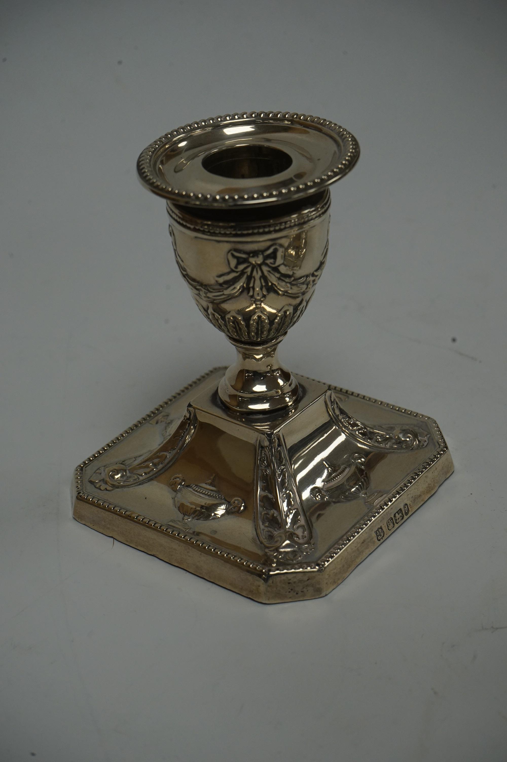 A pair of Edwardian silver mounted dwarf candlesticks, with swag and ribbon decoration, by James Deakin & Sons, Sheffield, 1901, height 92mm, weighted. Condition - poor to fair